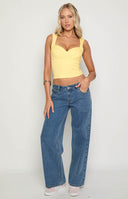 girl wearing low rise mid wash denim jeans paired with black sandals