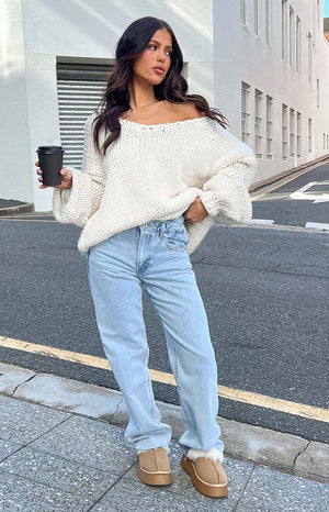 Light blue uneven waist denim jeans with raw hem.